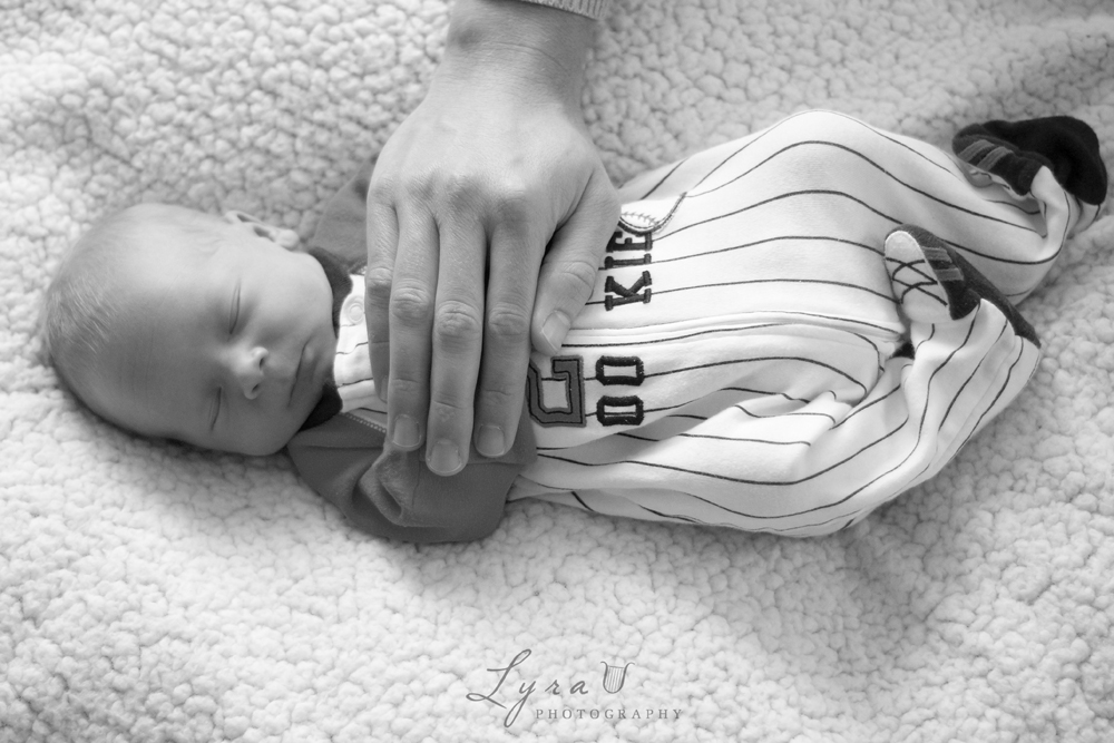 Daddy's hand on baseball baby